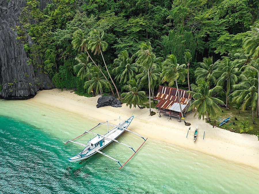 Outrigger boat moored at a wild beach on Palawan west coast