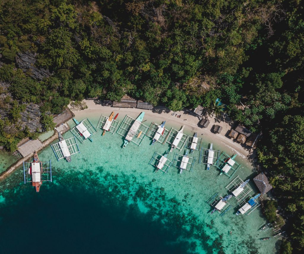 Bangka outrigger boats anchored in a cove on a Port Barton island hopping day